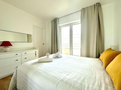 - une chambre avec un lit blanc, une commode et une fenêtre dans l'établissement Tres Bel Appartement 6P Terasse - Levallois, à Levallois-Perret