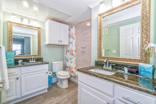 La salle de bains est pourvue d'un lavabo, de toilettes et d'un miroir. dans l'établissement Mermaid Cove Pathway to the Sea!, à Île Padre