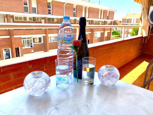 a bottle of water and two glasses on a table at Sun pool duplex apartment by HLCLUB Agency in Vilanova i la Geltrú