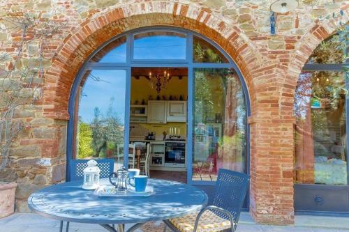 una finestra ad arco con tavolo e sedie blu di Wunderschöne Ferienwohnung in Monte San Savino mit gemeinschaftlichem Pool, Garten und Grill a Monte San Savino