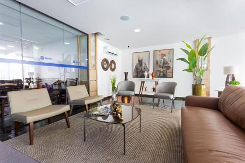 a living room with a couch and a table and chairs at Hotel Dan Inn Express Ribeirão Preto By Nacional Inn in Ribeirão Preto