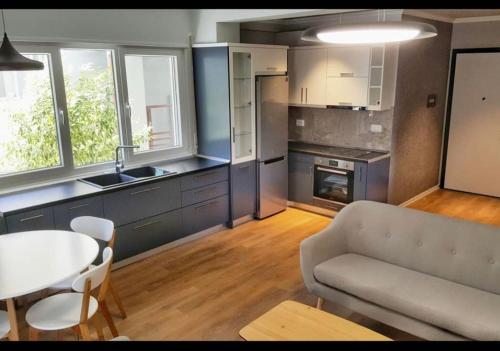 - une cuisine avec un canapé et une table dans une chambre dans l'établissement Sunrise Comforts, à Tirana
