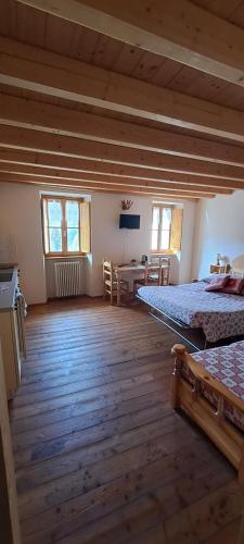 a large room with two beds and a table at ALBERGO DIFFUSO ORNICA NEL CUORE in Ornica