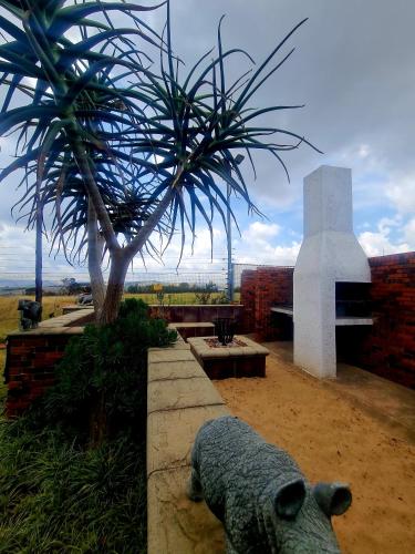 a statue of a sheep next to a palm tree at Rocky Aloe Escape in Krugersdorp