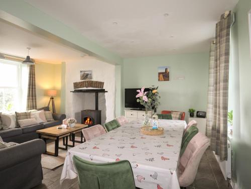 a living room with a table and a fireplace at Tregynrig Bach in Cemaes Bay