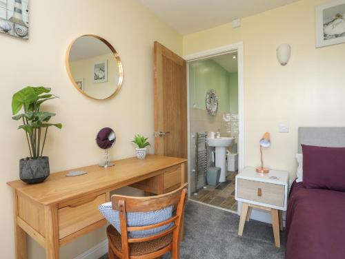 a bedroom with a desk and a bed and a mirror at Tregynrig Bach in Cemaes Bay