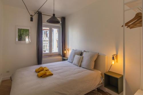 - une chambre avec un lit doté d'un peignoir jaune dans l'établissement Appartement avec vue sur vignoble, à Barr