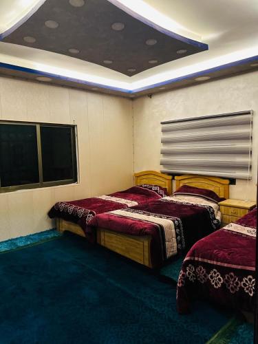 a room with three beds in a room at فيلا الجبل in Sūf