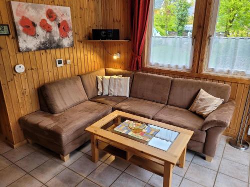 uma sala de estar com um sofá e uma mesa de centro em Gemütliches Ferienhaus Lea für 5 Personen mit Sauna und Kaminofen von Privat im Ferienpark Extertal em Extertal