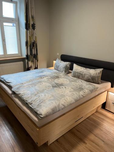 ein Bett in einem Schlafzimmer mit einem Holzrahmen in der Unterkunft CityDreams mit Altbau Flair in Lörrach