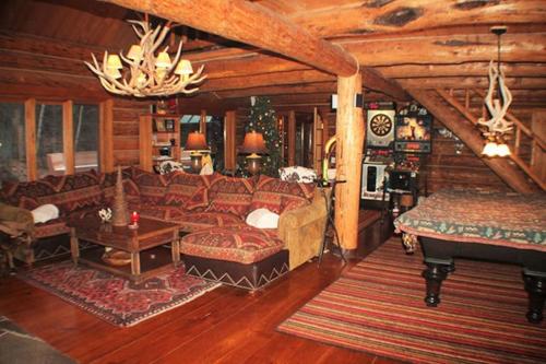 a living room with a couch and a piano at The Kresge Kabin - Authentic Grand Log Cabin. in Vermont Ventures