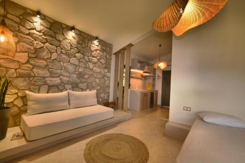 a bedroom with a stone wall and a bed with pillows at Villa Emilia Suites in Pachis