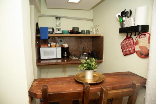 a wooden table in a kitchen with a microwave at El Yaguacil Aparta Hotel in Jarabacoa