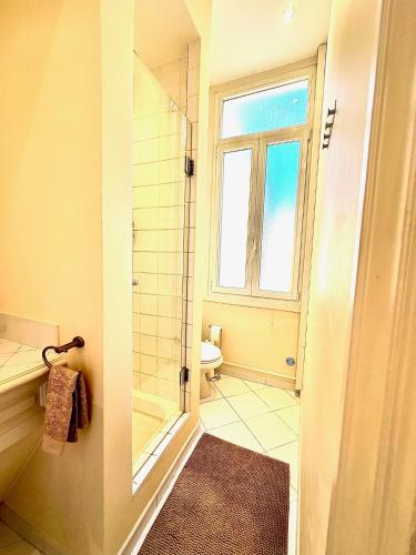 baño con ducha y aseo y ventana en Studio au calme à deux pas du Palais des Festivals, en Cannes
