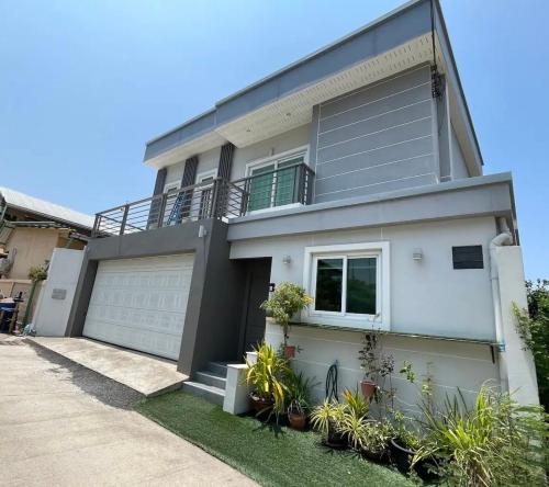 a large white house with a garage at Michelle house pool villa in Pattaya South