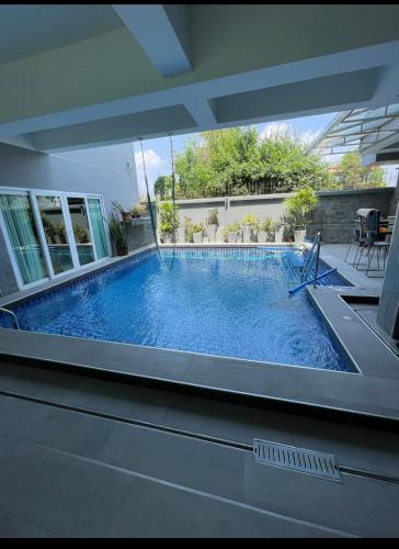 a swimming pool in a house with a large window at Michelle house pool villa in Pattaya South