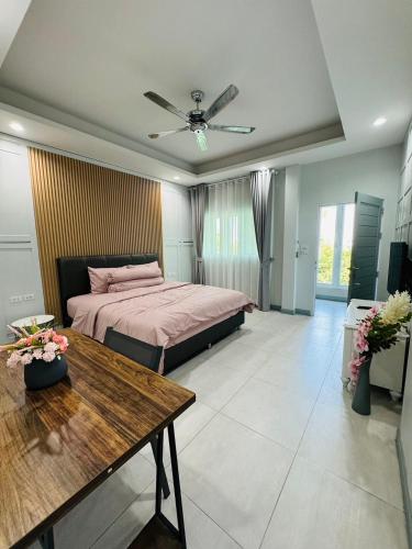 a bedroom with a bed and a table in it at Michelle house pool villa in Pattaya South