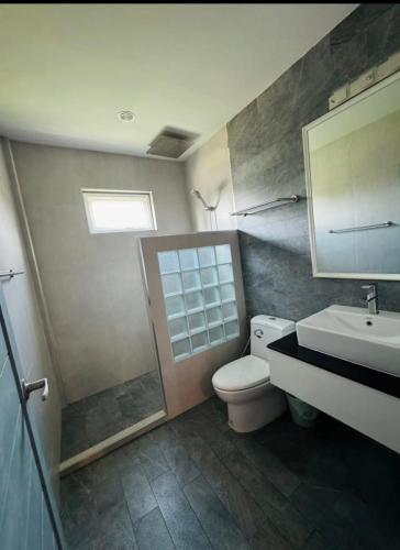 a bathroom with a toilet and a sink and a mirror at Michelle house pool villa in Pattaya South