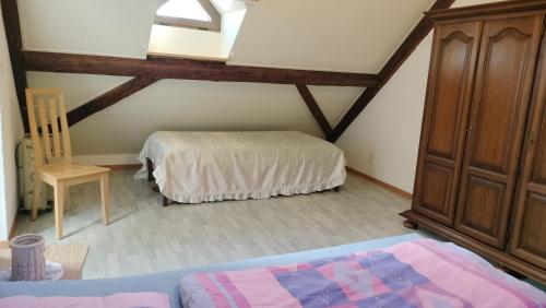 a attic room with a bed and a dresser at BnB LES OISEAUX, chez Lidia, 26m2 à 44m2, 2ème étage in Vendlincourt