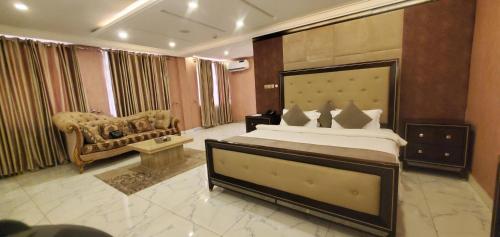a large bedroom with a large bed and a couch at The Palms Hotel in Abuja