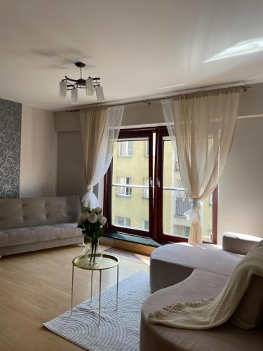 a white living room with a bed and a couch at CentralVibeWro in Wrocław