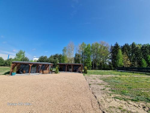 zwei Pavillons auf einem Feld mit Bäumen im Hintergrund in der Unterkunft Domki303 in Mszczonów