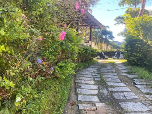 a stone path with flowers on the side of a house at Pousada Portal de Lumiar in Lumiar