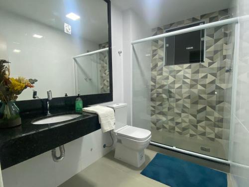 La salle de bains est pourvue d'un lavabo, de toilettes et d'une douche. dans l'établissement Espaçoso apartamento reformado em Copacabana, à Rio de Janeiro