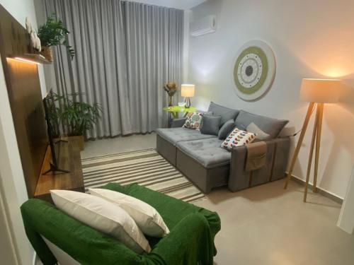 - un salon avec un canapé gris et un fauteuil vert dans l'établissement Espaçoso apartamento reformado em Copacabana, à Rio de Janeiro