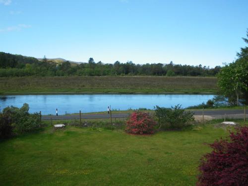 a view of a pond in a field at Rowanhill Cottage in Acharacle