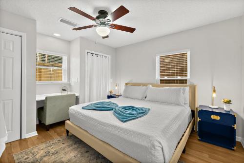 a bedroom with a bed with a ceiling fan and a desk at Cozy Uptown Guest House in Saint Augustine