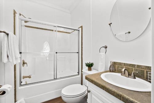 a bathroom with a toilet and a sink and a mirror at Treetop Cottage - 3 blocks from Historic District in Saint Augustine