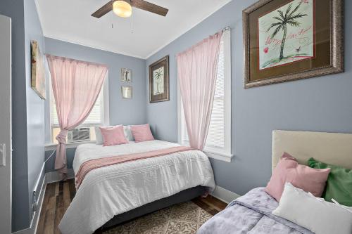 2 letti in una camera con tende rosa di Casa Bella- Chic, Retro Apt- Steps to Historic District! a St. Augustine