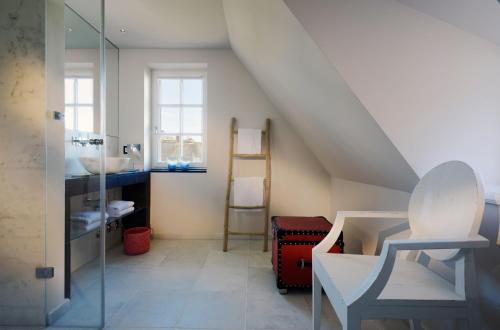 a bathroom with a staircase with a sink and a mirror at Hotel Duene in Rantum