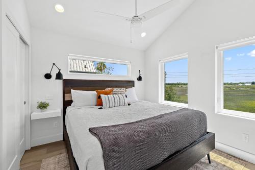 a bedroom with a bed and two windows at 200 Riberia - Downtown Waterfront Luxury Home in Saint Augustine