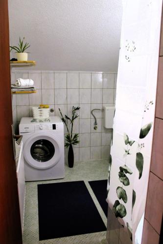 a bathroom with a toilet and a washing machine at Svila Apartmani in Bihać