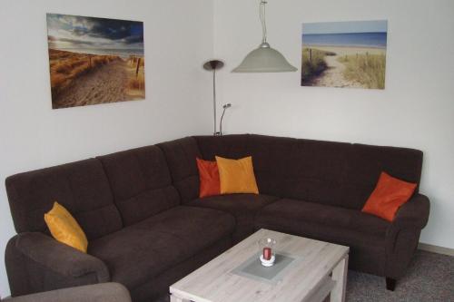 a living room with a brown couch and a coffee table at Komfortable Ferienwohnung mit großem Garten in Lütjendorf