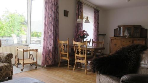 een woonkamer met een tafel en stoelen en een raam bij Große Wohnung in Zwickau mit Terrasse, Grill und Garten in Zwickau