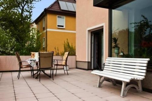a patio with a bench and chairs and a table at Große Wohnung in Zwickau mit Terrasse, Grill und Garten in Zwickau