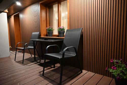 czarny stół i krzesła na drewnianym tarasie w obiekcie Ververitsa's House w mieście Metsovo