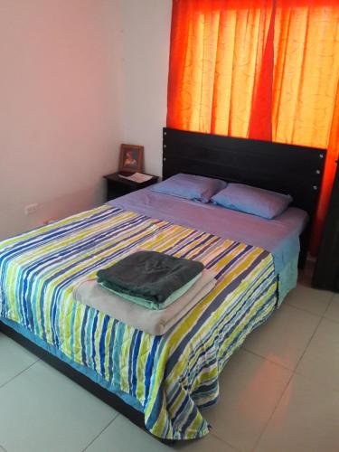 1 dormitorio con 1 cama con una manta a rayas de colores en Casa 4, en Medellín