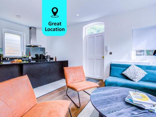 een woonkamer met een blauwe bank en een tafel bij Charming 1BR Apartment in a gated complex and a short walk from Queens Park Tube in Londen