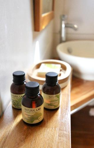 deux bouteilles de pots à herbes sur un comptoir en bois dans une salle de bain dans l'établissement studio, vue sur mer et montagne, à Saint-Florent