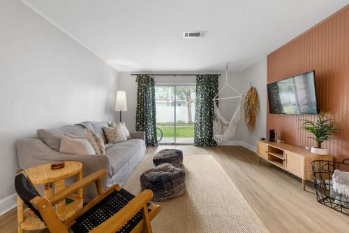 a living room with a couch and a tv at Island Suite - Walk to Downtown! in St. Augustine