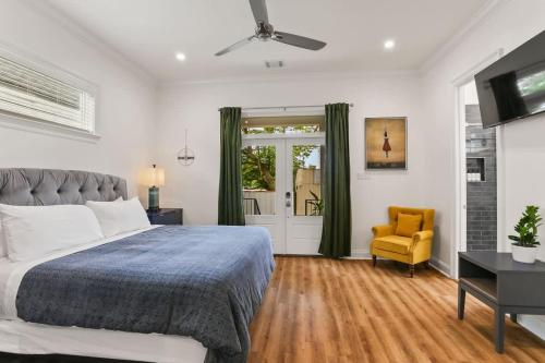 um quarto com uma cama e uma cadeira amarela em Luxury New 3BD Home with Parking and Private Yard em Nova Orleans