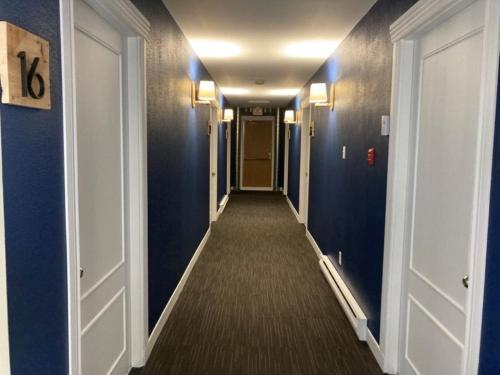 a hallway with blue walls and a long corridor at Auberge Les Sources in La Malbaie