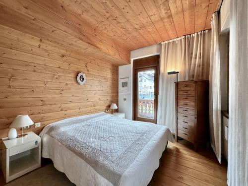 a bedroom with a bed and a wooden wall at Classy 4 bedroom few steps from centre in Cortina dʼAmpezzo