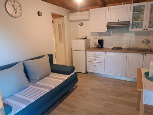 a living room with a couch and a kitchen at Robinson house Sea & olives in Tisno