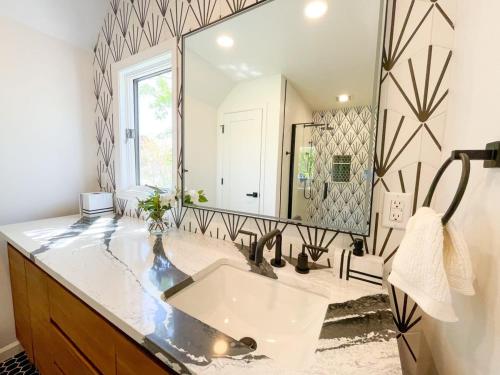 a bathroom with a sink and a large mirror at Luxury Waterfront Villa Dock Game Room Sunset Views in Ocean City