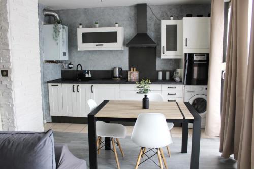 a kitchen with a wooden table and white cabinets at Le Cosy Appart - Balcon parking - Proche Eurexpo Stade in Saint-Priest